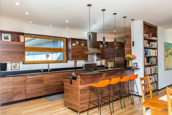 in the kitchen, as throughout the interior, the architect custom-designed the black walnut cabinetry to express its vivid grain and rich color.
