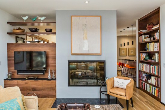 A double-sided fireplace marks the transition from the the Music Room and Sitting Area to the Dining Area and main Living Room.