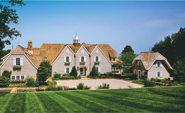 Skirl siding, oversized gables, and custom shutters and flowerboxes bestow a storybook character on the house and the husband's home office (below, right).