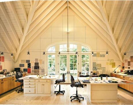 A wooden walkway leads from the house's back patio down to the water (opposite, bottom). The high-ceilinged design studio (this page) occupies the upper story of the pool house (opposite, top).