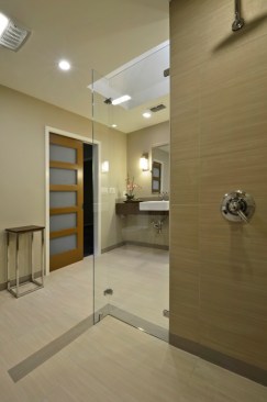 In the curbless shower, the tile runs in the direction of a large drain, facilitating water capture. 