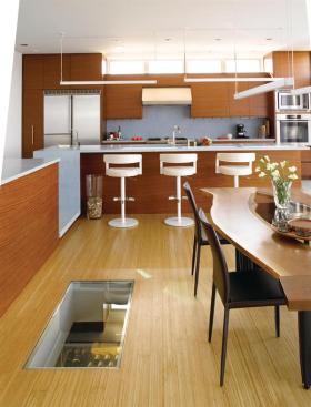 Cooking and serving functions occupy a platform one step up from the dining area, which places the counter at an appropriate height for barstools. A window in the floor offers a glimpse into the wine cellar.
