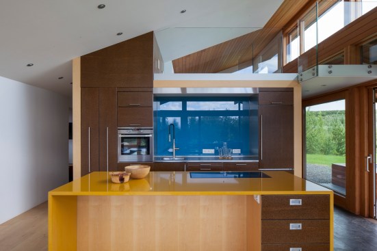 The bright yellow countertop creates a striking contrast to the dark wood finishes in this kitchen.&nbsp;Project: Big Little Rock by MINARC