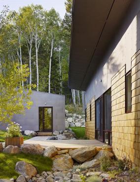 The colors of the cedar shingles and bonderized steel play off the landscapes natural hues.