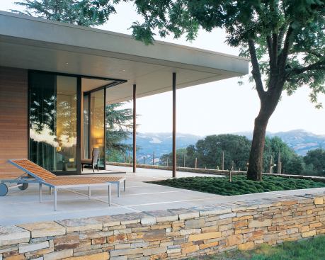 Sliding glass doors open up the corner of the master bedroom to views of the vineyard and mountains beyond. Ample terraces establish a close connection between house and site.