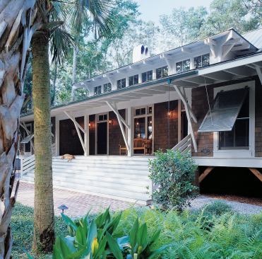 Low Country forms and West Indies details mark the exterior of both the main house and its two-bedroom guest cottage.