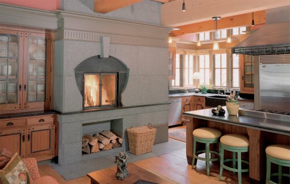 Baker designed convenient firewood niches into the living room and kitchen fireplaces. Reclaimed fir planks cover the floors.