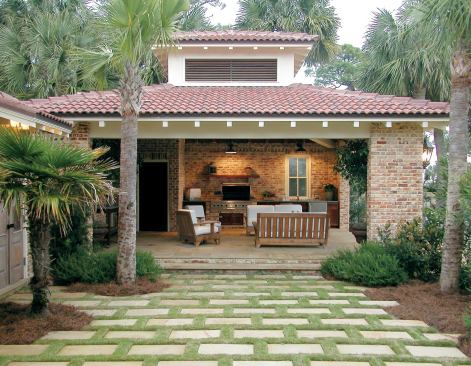 "Waste not" was Michael Thomas' approach to the expensive sandstone pavers the clients had imported from Britain for the terraces and pool deck. He used leftover pavers in the courtyard between house and pool house. Soft zoysia grass is planted between the pavers.