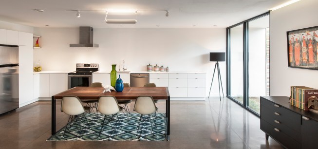 White walls and millwork reflect the light coming in primarily from north- and south-facing sliding doors. 
