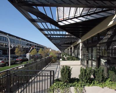 As is so often the case, the fa&ccedil;ades' most animating feature grew out of programmatic and landmark-status constraints. The distinctive triangular balconies —which add roughly 100 square feet of precious outdoor space to each unit—are integrated into an open grid mimicking the covered canopy that once protected the dockworkers and produce.