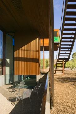 Strategic shading, an industrial mesh screen, and a surrounding water element help passively cool the studio courtyard.