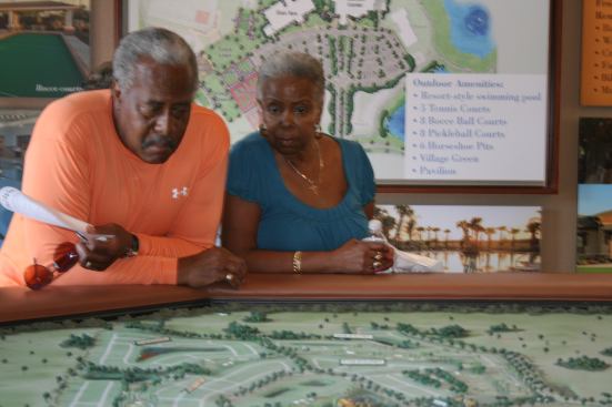 A couple studies the community model inside the sales center.