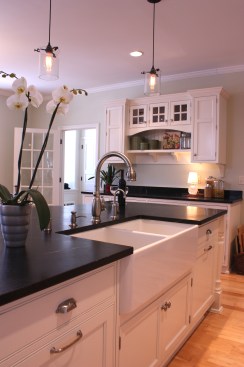 This farmhouse had received several updates and renova-
tions over the years. However, the floor plan was conflict-
ing amongst the kitchen, laundry, mudroom, and powder 
room. A complete reorganization of the first floor was 
achieved through multiple structural changes that al-
lowed for a larger kitchen and created better flow be-
tween adjacent rooms. The kitchen includes custom 
painted cabinetry, a farmhouse style sink, and soapstone 
countertops. A commercial size Viking range, hood, and 
Sub Zero refrigerator bring a theme of stainless steel to 
the kitchen which is accentuated by brushed nickel hard-
ware and island faucet. Specialty lighting, glass door 
cabinets, and a grand, eight foot island are just a few of 
the features that make this kitchen stunning.