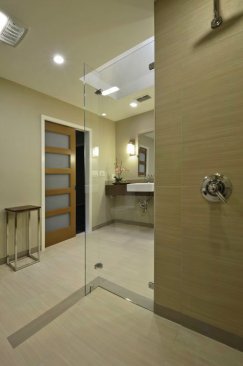In+the+curbless+shower%2c+the+tile+runs+in+the+direction+of+a+large+drain%2c+facilitating+water+capture.+