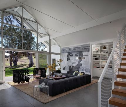 Entering a low porch on the more opaque north side under the loft above, the light-filled Hupomone Ranch house opens up to the long view south and gathers the bedrooms and kitchen to either side.