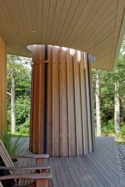 The design team wanted the shower to read as the strongest part of the porch composition, so they produced a circular opening in the porch overhang so the shower stands as an uninterrupted form. 
