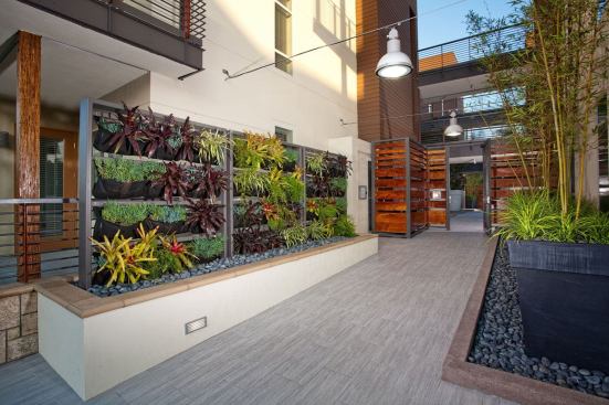 The courtyard features a linear fountain, a living green wall, an outdoor fireplace, barbecue grills, and a community&nbsp;garden.