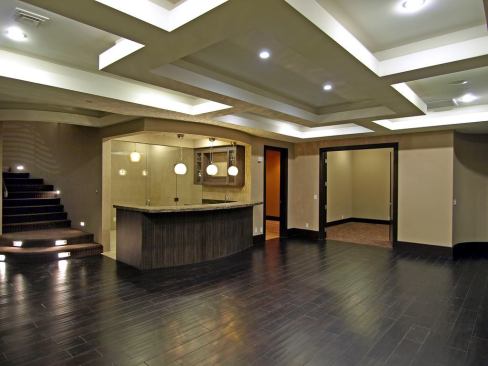 Among the house's many recreational areas are the wine bar and glass-enclosed wine cellar inside the larger game room, adjacent to the movie theater room and home gym.