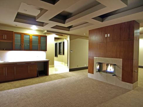 The master suite is divided into two parts separated by the freestanding fireplace wall: a sitting area, shown here, and sleeping area behind the fireplace wall.