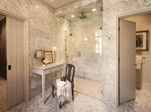 The larger, more open shower has become the focal point of the master bathroom. It boasts a thermostatic control valve, a normal shower head, a rain head, and a hand-held sprayer along with a remote sound system.