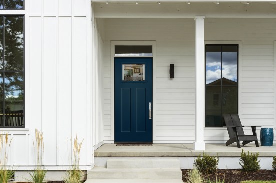 Heritage Series Smooth Fiberglass Exterior Door with Heartland Glass - Outside, set the stage for a contemporary yet rustic look with simple white siding and a shaker panel fiberglass door with decorative glass.