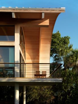 A cantilevered deck extends living space outdoors and offers unobstructed views of the surrounding trees and water beyond.