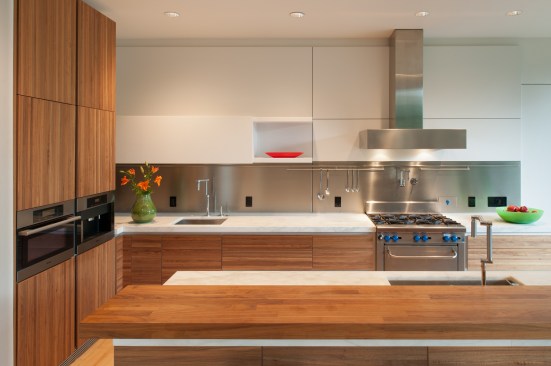 Natural wood cabinetry contrasts modern white finishes for a kitchen that is both modern and organic.&nbsp;Project: Riggins House by Robert Gurney Architect
