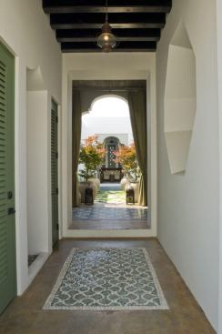 This modest, Spanish-style townhouse is oriented along two axes that culminate in a center courtyard. The home’s entry hall is intentionally dark in contract to the sun-drenched oasis in the middle of the plan.&nbsp; Decorative floor tiles and Andalusian archways direct the eye down the hall and back outside. 
Architect: Khoury & Vogt Architects, Alys Beach, Fla. 
Builder: Wave Construction, Rosemary Beach, Fla.