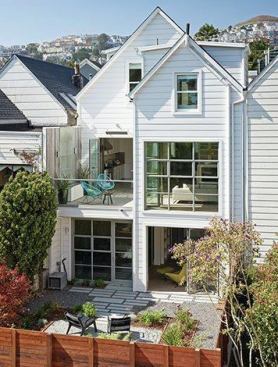 The rear façade with the doors to the deck and backyard open. 