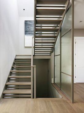 One of the first things people see upon entering is a glass partition and main floor stairwell. “It lets you know you’re not in Grandma’s Victorian,” Feldman says. Built on site in the basement, the stairs pull in light from skylights above. Juxtaposed next to wood paneling, wainscoting, and other wood work, “the floor-to-ceiling screen floor draws you in and peaks your interest.”