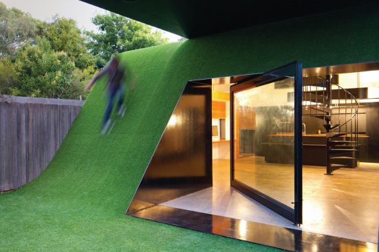 To accommodate a family of five as well as take advantage of what little sun this narrow back yard receives, Maynard placed a two-story&nbsp;addition at the back edge of the site. The lower level kitchen is encased in a hill, which provides the family with lunging and playing space.