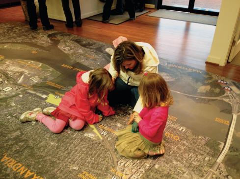 Most home shoppers immediately stop at the aerial map to pinpoint where they live and work. This mother and her children dropped to the floor to find where their home and school are.