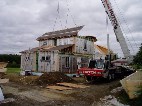 The home has high levels of insulation and air-tight construction. Here, roof panels are put in place. 