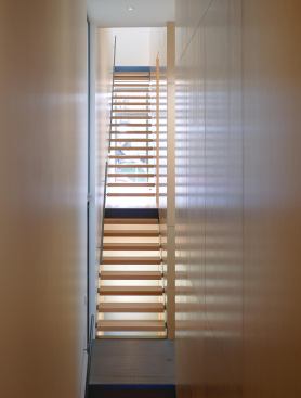 Open risers admit natural light from windows at the front and rear and a long skylight above.

