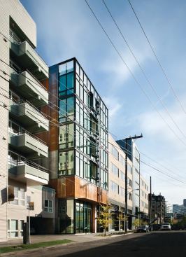 The mixed-use building's active front elevation fits in nicely with the area's residential and commercial context.