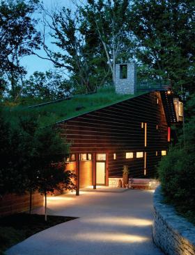 The house is a 24-foot-by-150-foot bar that spans a seasonal creek and preserves natural drainage patterns.