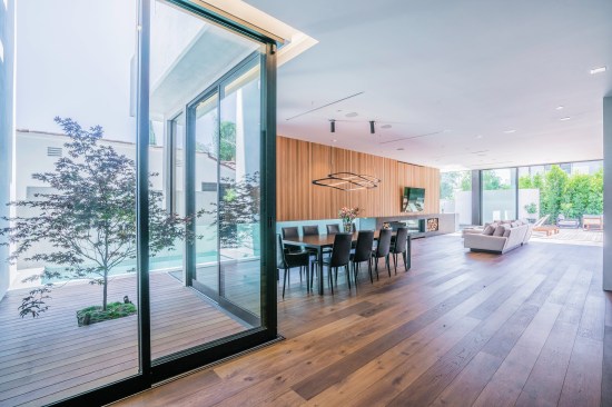 The home's kitchen and living room flow together into the outdoor living area.