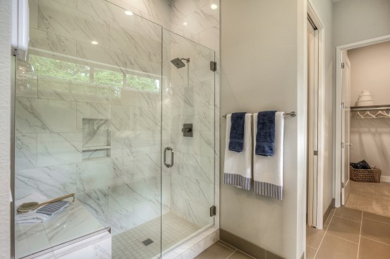 The large showers at Quadrant's Viscaia community in Bellevue, Wash., feature a bench and built-in shelving.