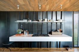 Folded blackened steel panels help express the new
structural system. The panels—solid or mesh, depending on the application—are used in various locations
throughout the home from wall panels to lighting details to stair risers.